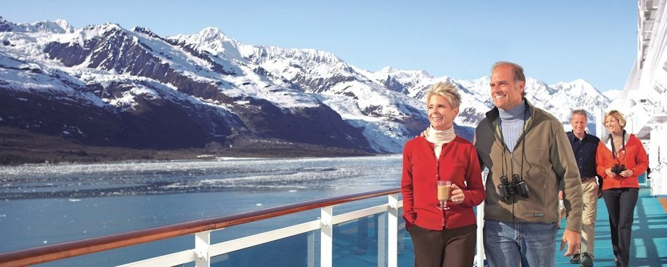 Adults on deck sightseeing on an Alaskan cruise