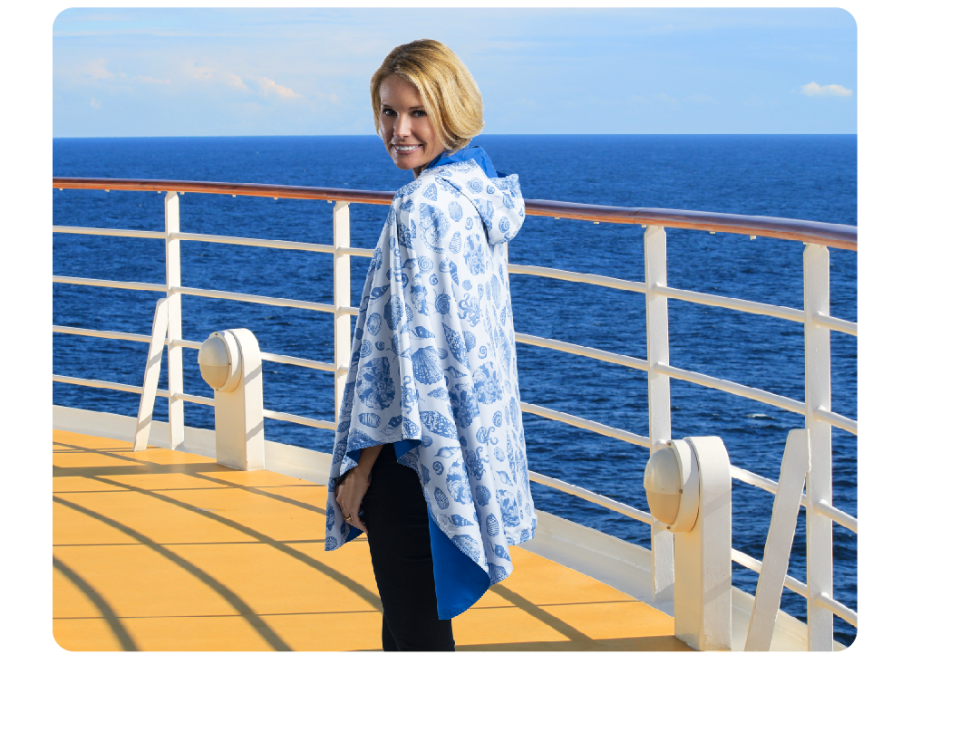 Woman on the deck of a cruise ship wearing an Ocean/Seashells print RainCaper