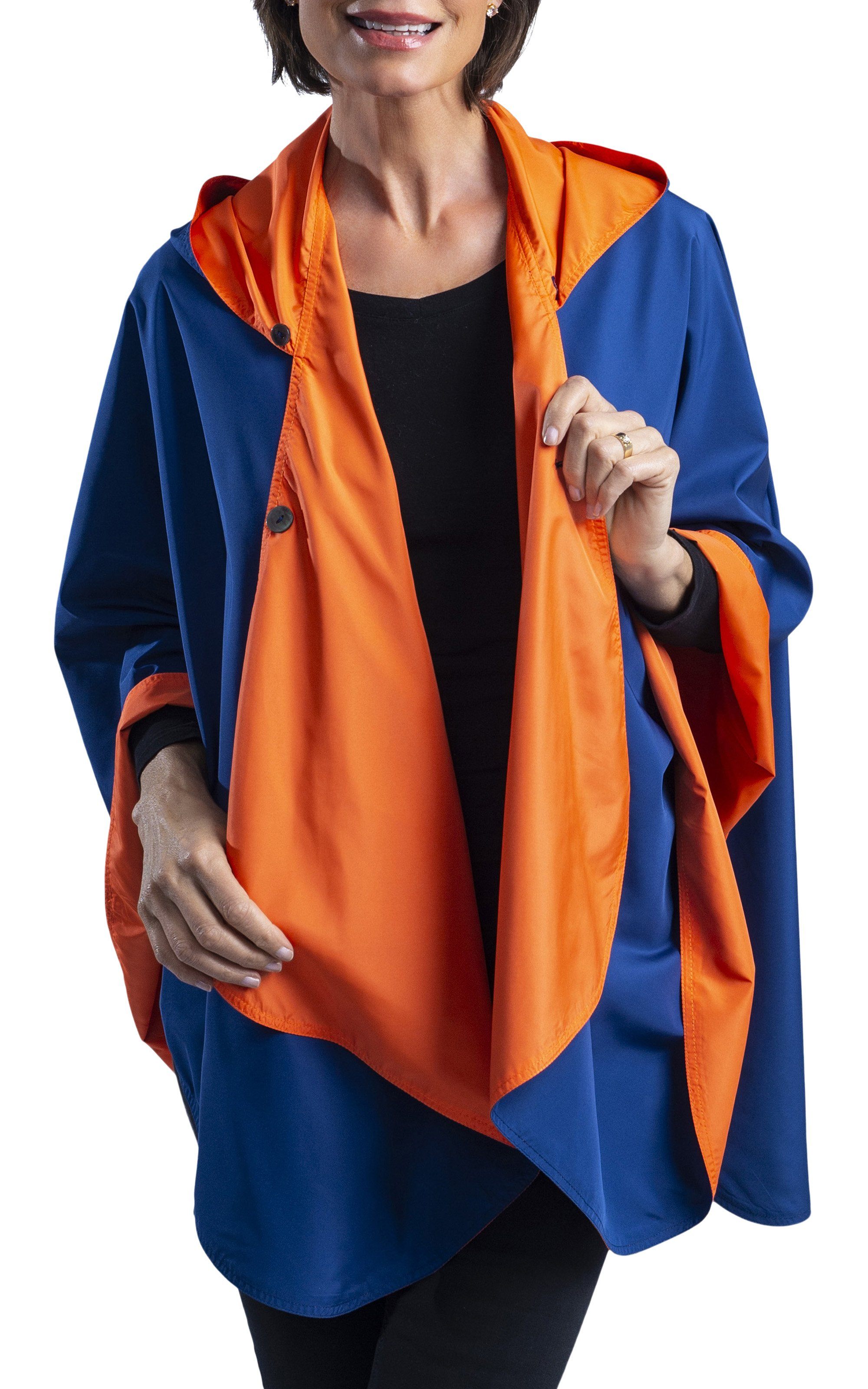 Woman wearing a Navy Blue & Orange Wind & Rainproof Sports Cape with  the Navy Blue side out, revealing the Orange  print at the lapels,neckline and cuffs