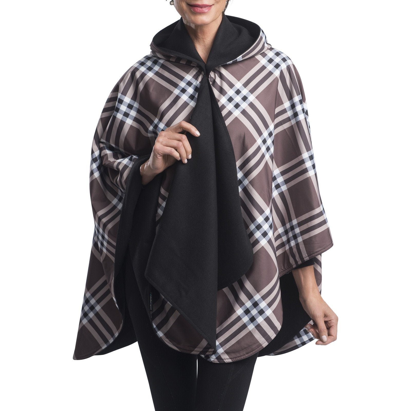 Woman wearing a WarmCaper Rainproof Black & Coco Plaid rain and travel cape. The reversible cape is warm black; the Rainproof Coco Plaid print is visible on the hood and lapels